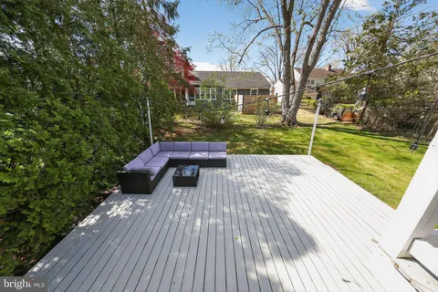 a view of a patio with table and chairs and wooden fence