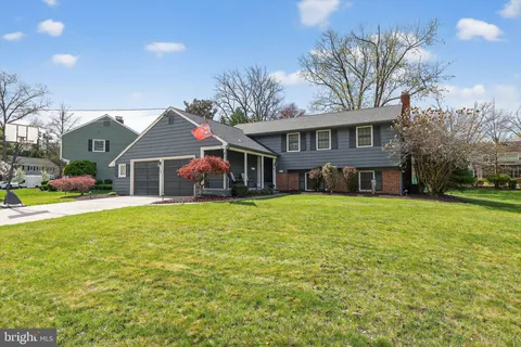 a front view of a house with yard patio and a garage