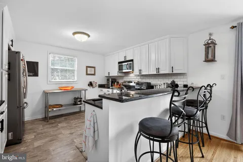 a kitchen with granite countertop a table chairs stove and cabinets