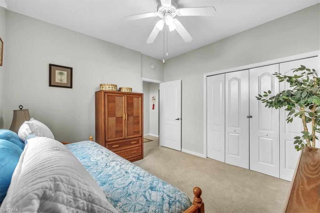 8075 Tiger Cove, Unit 1706 Naples, FL 34113 - Photo 24 of 50 Bedroom with ceiling fan, a closet, and carpet floors