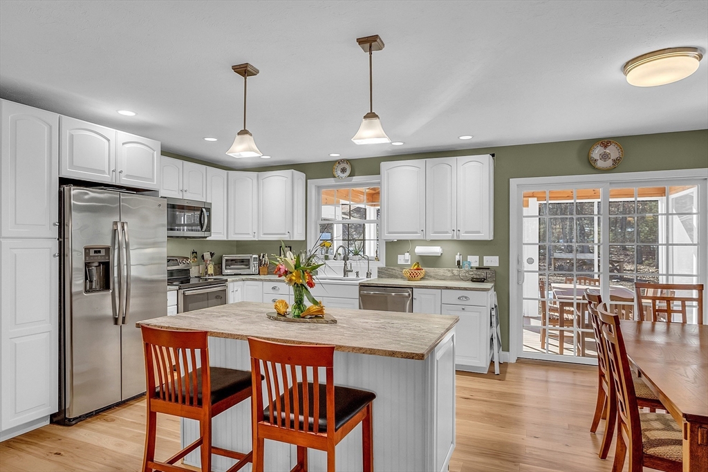 862 Reservoir Road Lunenburg, MA 01462 - Photo 18 of 37 a kitchen with stainless steel appliances granite countertop a stove a refrigerator a kitchen island a table and chairs
