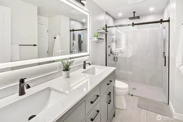 a bathroom with a sink vanity granite toilet and shower