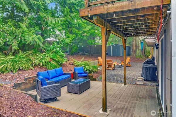 a view of a patio with table and chairs potted plants with wooden floor and fence