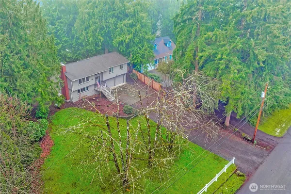 an aerial view of a house with a yard and trees