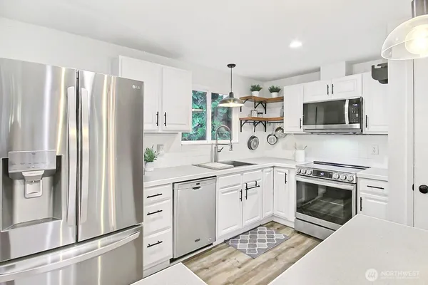 a kitchen with stainless steel appliances a stove a sink and a refrigerator
