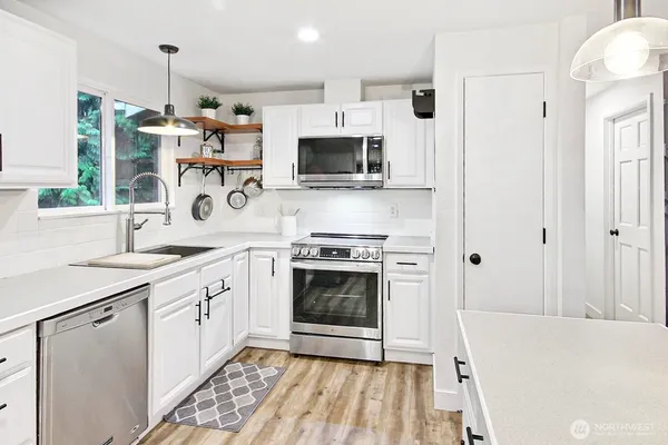 a kitchen with stainless steel appliances a stove a sink and a refrigerator