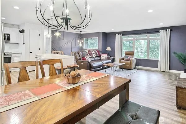 a living room with furniture a large window and wooden floor