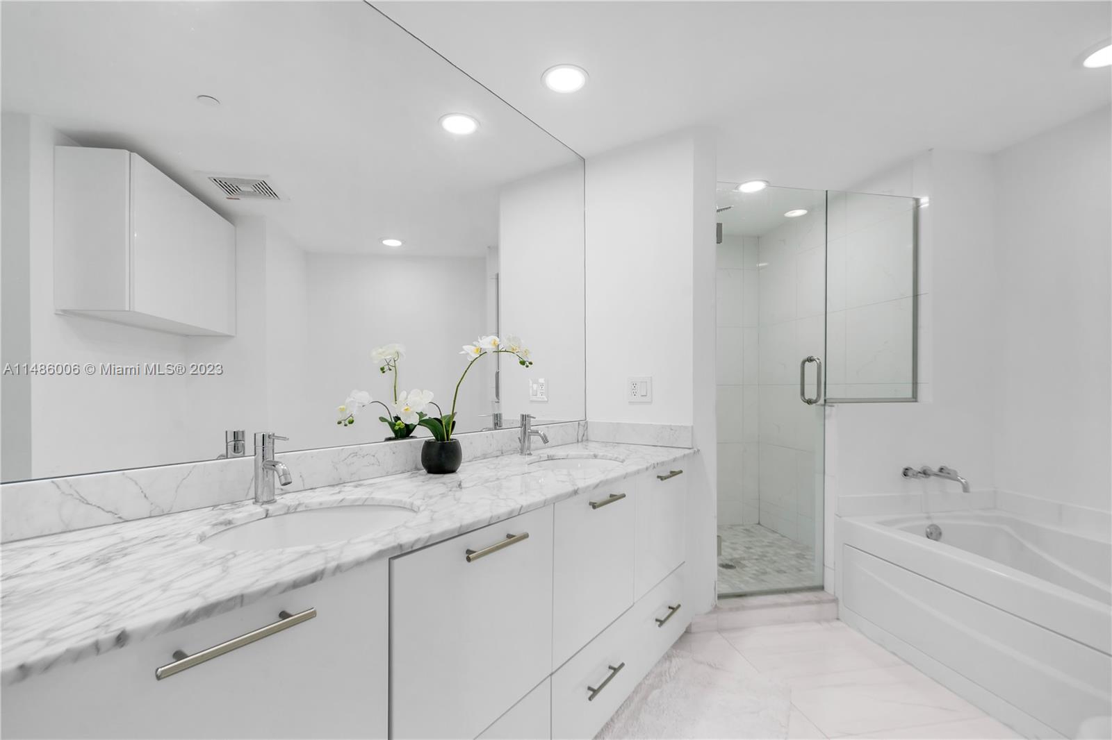 500 Brickell Avenue, Unit 2602 Miami, FL 33131 - Photo 15 of 38 a bathroom with a granite countertop sink mirror and bathtub