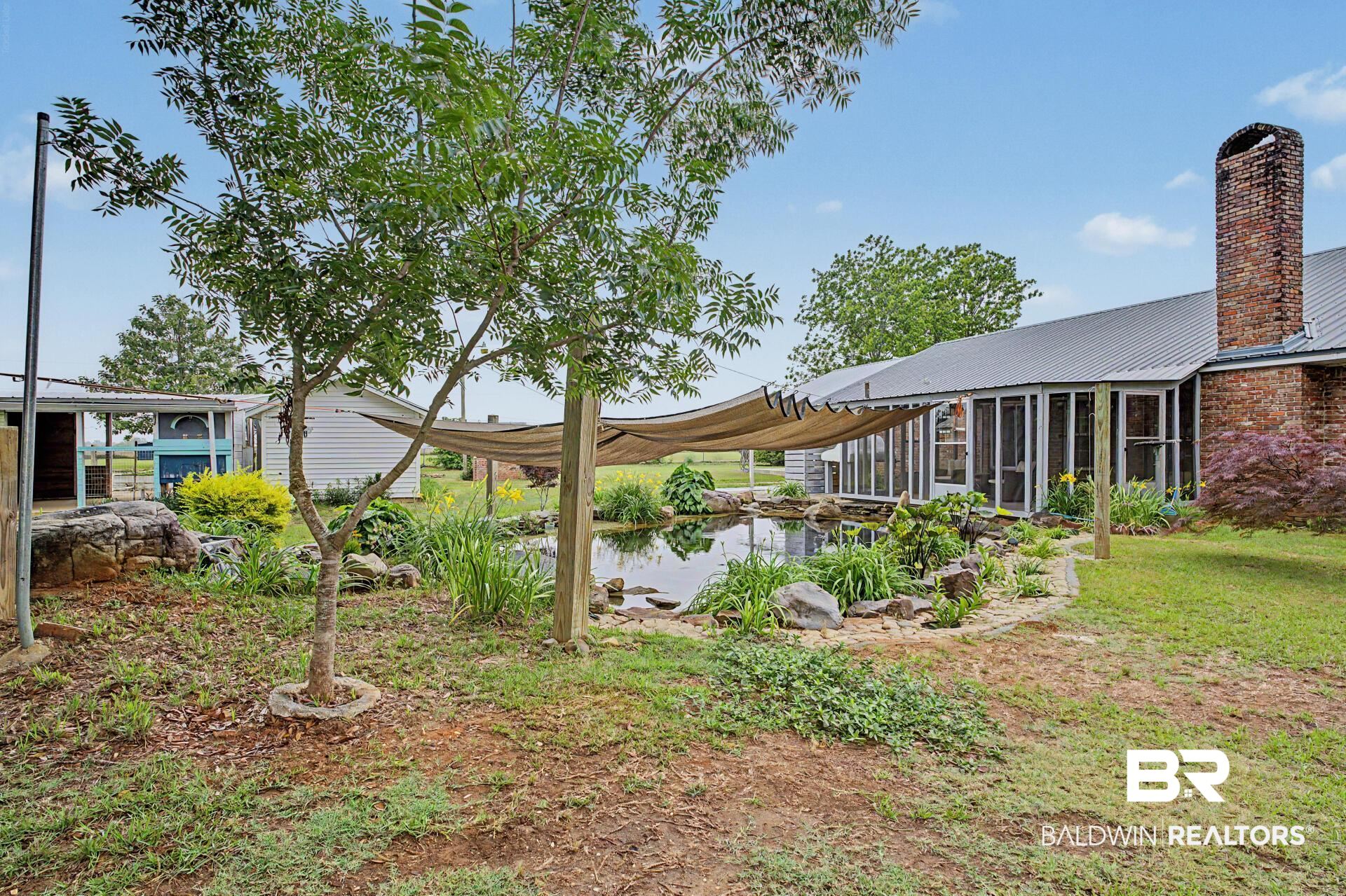 3791 Robinsonville Road Atmore, AL 36502 - Photo 17 of 47 Outdoor space featuring a pond with rock and plant landscaping