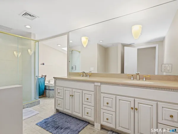 a spacious bathroom with a granite countertop sink a mirror a vanity and a shower