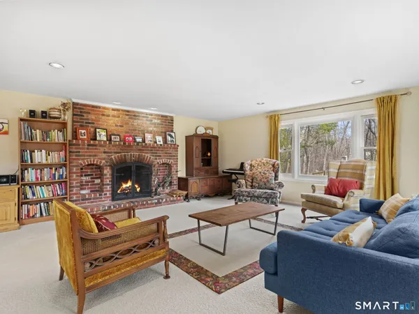 a living room with furniture a flat screen tv and a floor to ceiling window