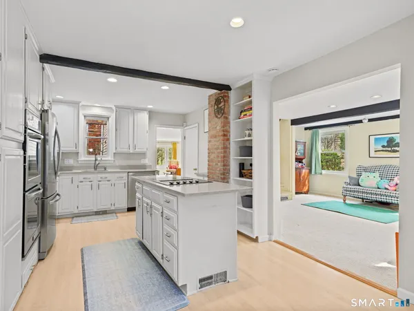 a kitchen with white cabinets and refrigerator
