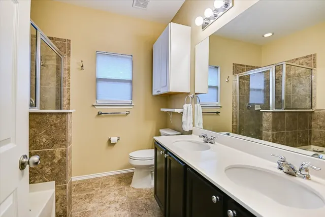 a bathroom with a sink a toilet and shower