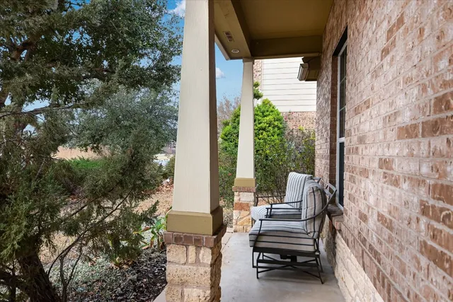 a view of a balcony with chairs and a potted plant