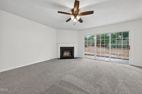 a view of an empty room with a fireplace and a window