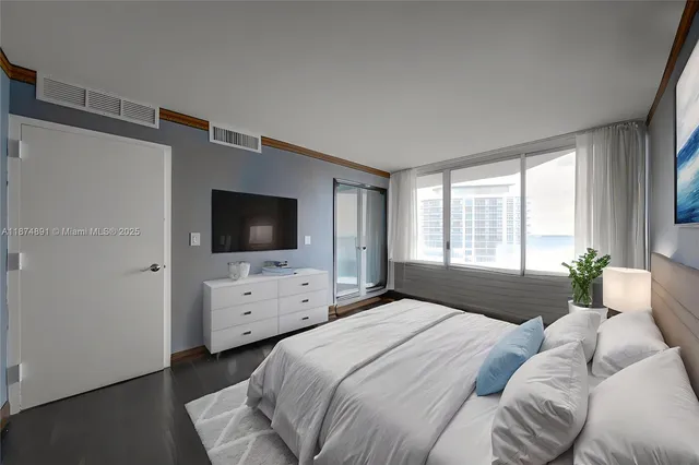a bedroom with a bed and flat screen tv