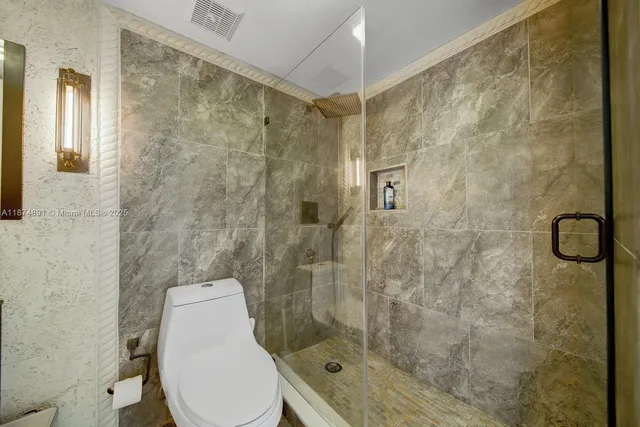 a bathroom with a toilet and a shower