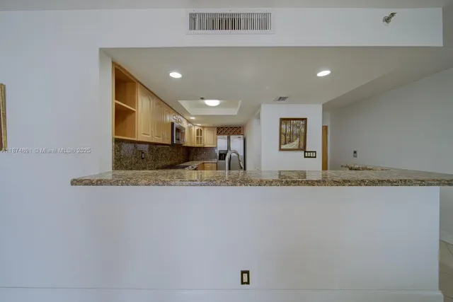 a view of kitchen with stainless steel appliances granite countertop refrigerator sink and stove