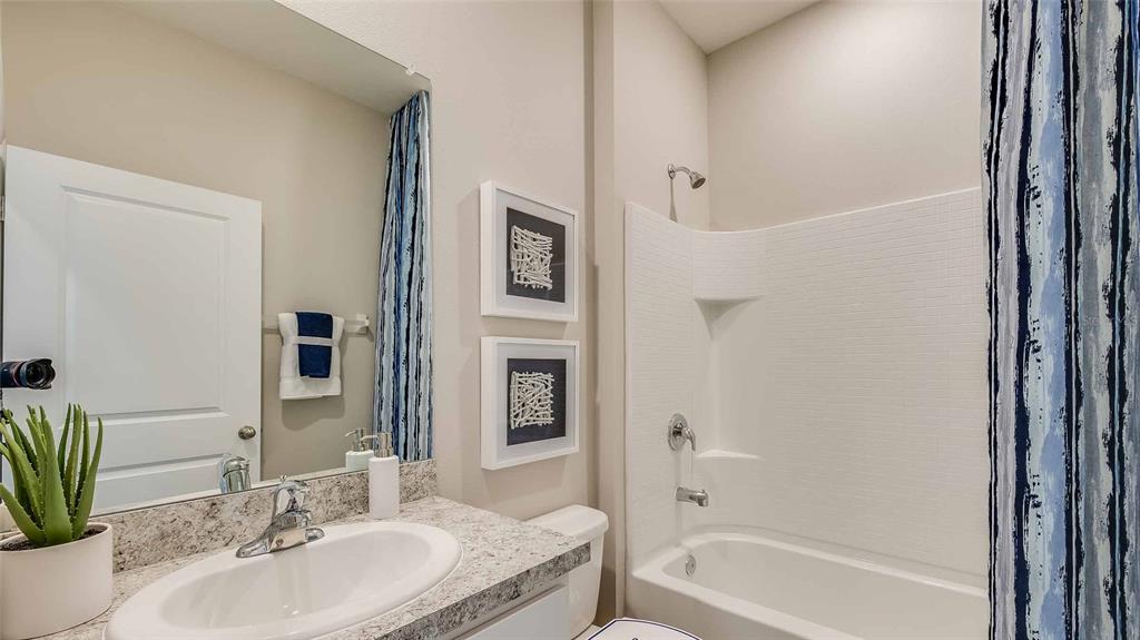 10726 Rabbit Grove Trail Palmetto, FL 34221 - Photo 14 of 28 a bathroom with a granite countertop tub sink and mirror