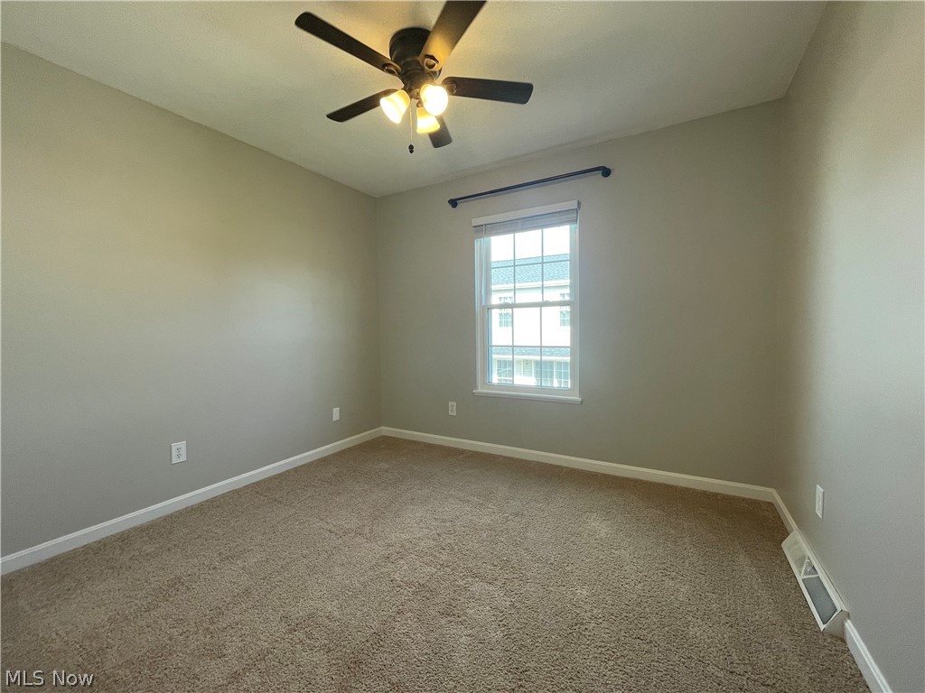 Bedroom featuring dark carpet and ceiling fan