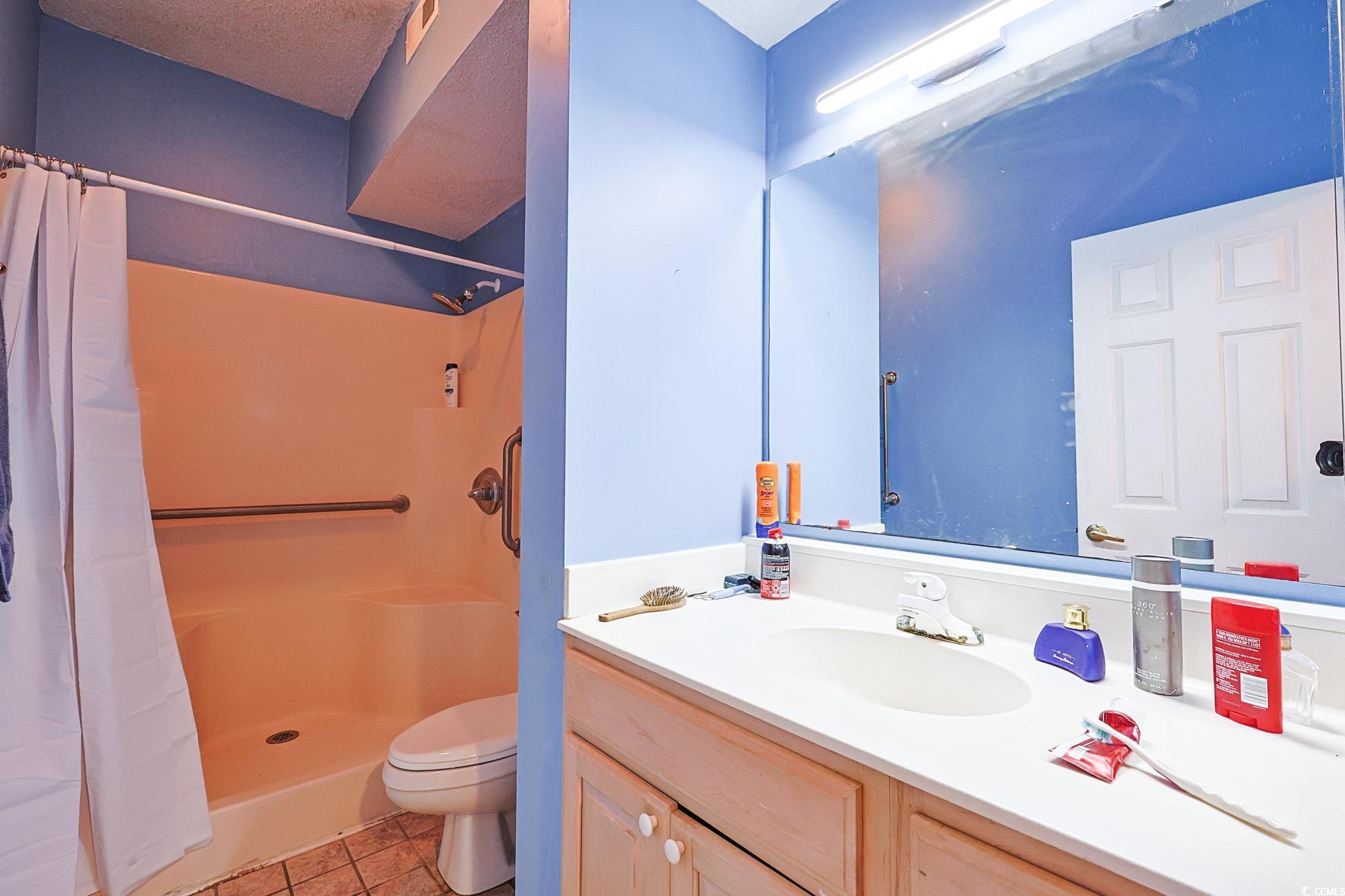 2302 Sweetwater Boulevard, Unit 2302 Murrells Inlet, SC 29576 - Photo 19 of 24 Bathroom with vanity, a stall shower, and light tile patterned flooring