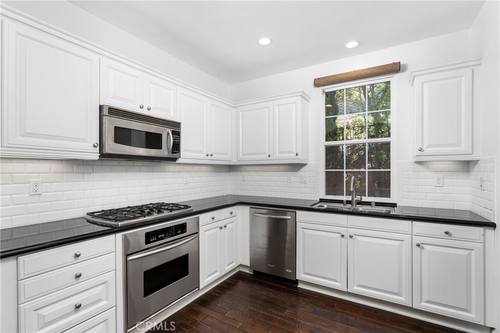 74 Clouds Irvine, CA 92603 - Photo 5 of 27 a kitchen with granite countertop a sink cabinets and stainless steel appliances