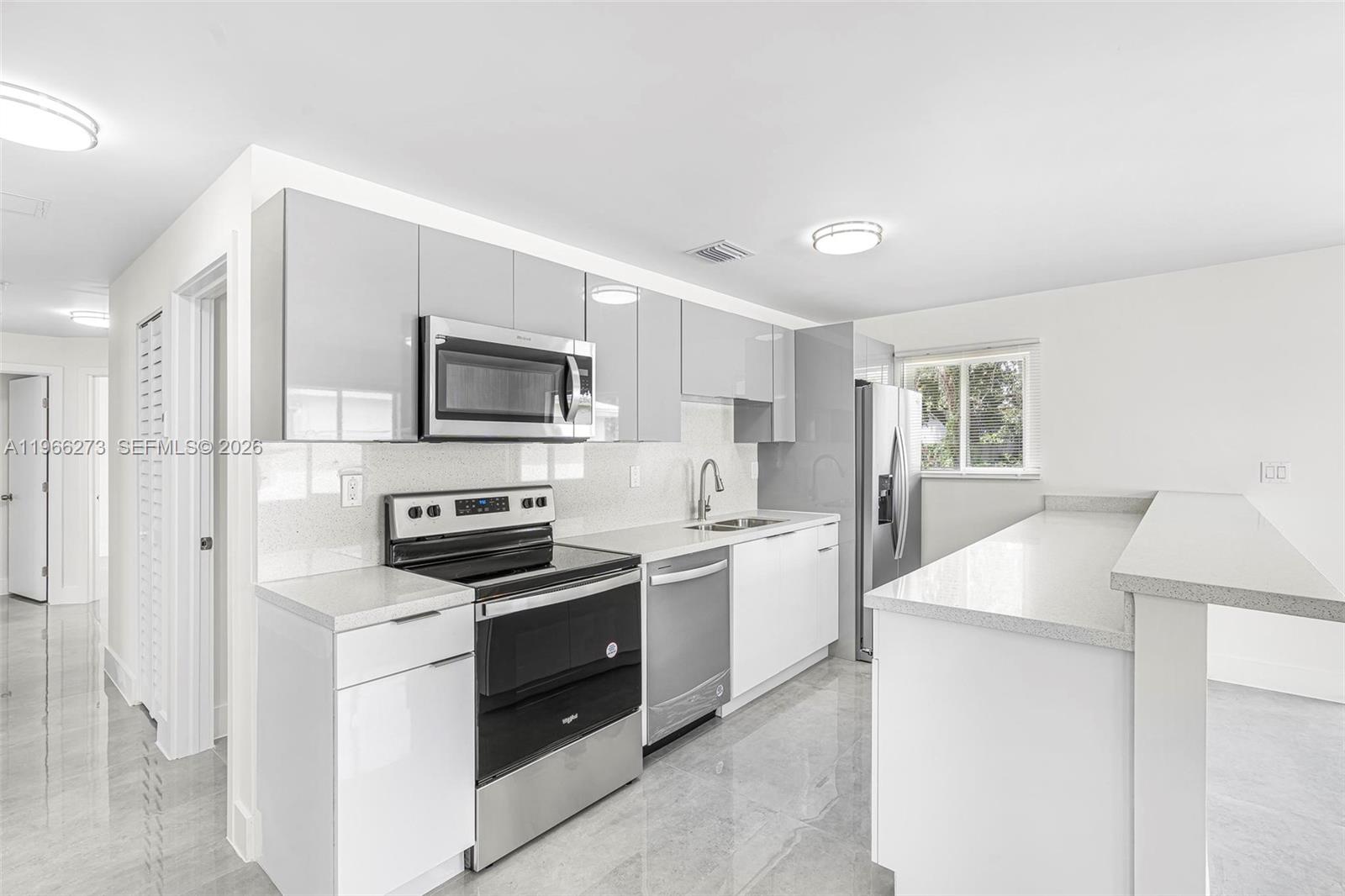 933 Northwest 50th Street Miami, FL 33127 - Photo 8 of 31 a kitchen with a sink stove and refrigerator