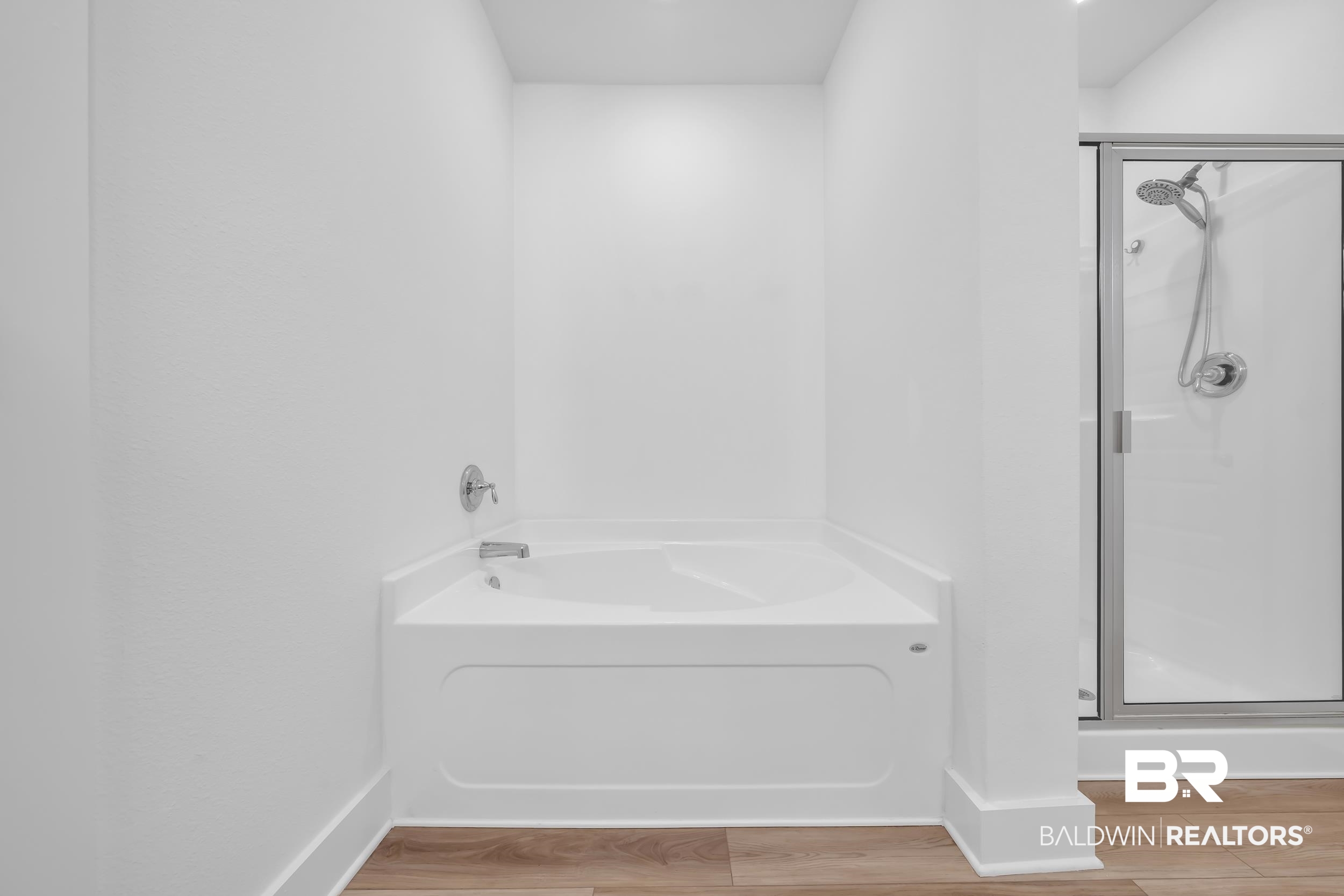 9933 Weller Cove Foley, AL 36535 - Photo 20 of 36 White built-in bathtub with polished chrome fixtures and wood-finish flooring