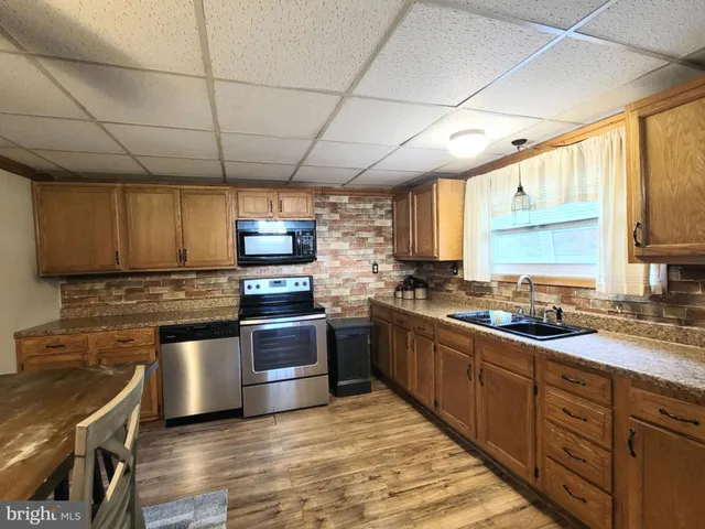 a kitchen with stainless steel appliances granite countertop a stove a sink dishwasher and a refrigerator