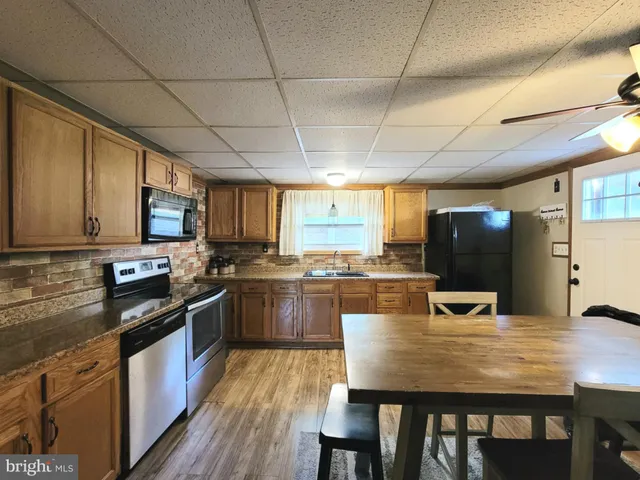 a kitchen with stainless steel appliances granite countertop wooden cabinets a stove top oven a sink and dishwasher