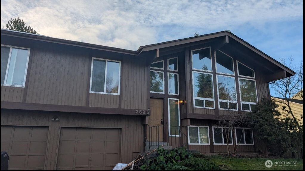 a front view of a house with plants