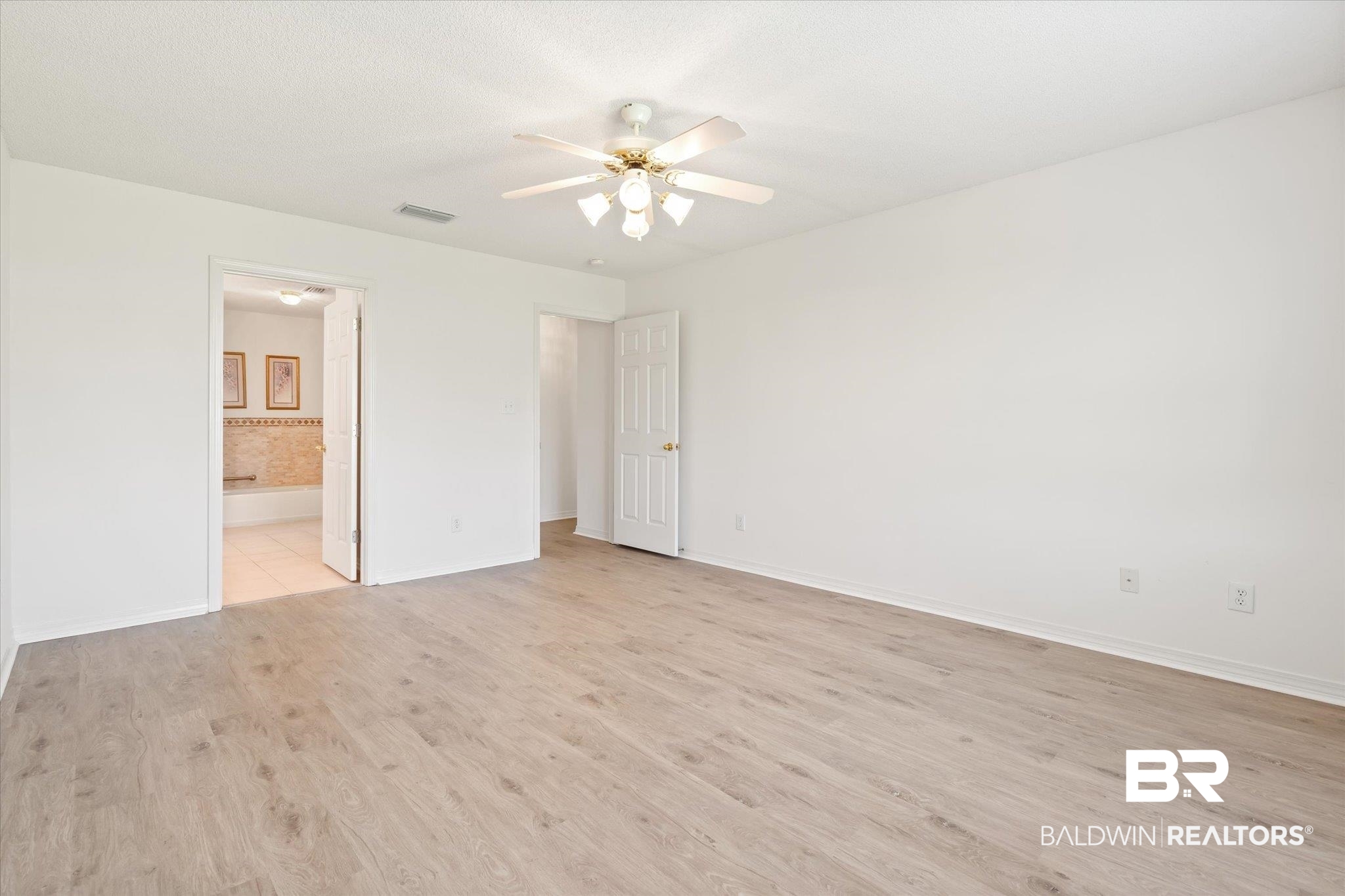 12520 Hunters Chase Foley, AL 36535 - Photo 24 of 32 Unfurnished bedroom featuring visible vents, light wood-style flooring, a ceiling fan, connected bathroom, and baseboards