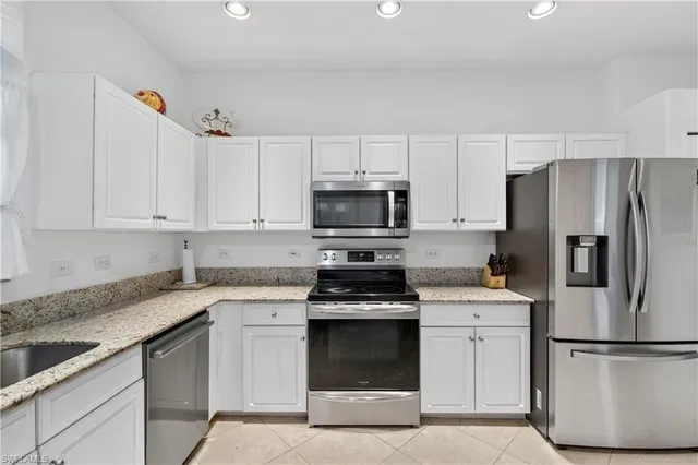 a kitchen with white cabinets and stainless steel appliances