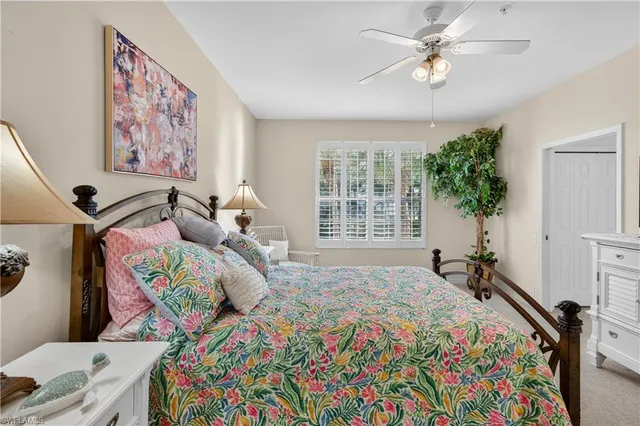 a bedroom with a bed a dresser and potted plant