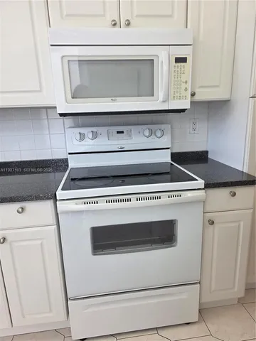 a stove top oven sitting inside of a kitchen