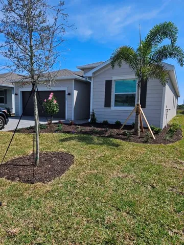 a view of a house with backyard and tree