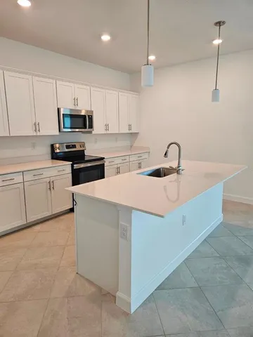 a kitchen with stainless steel appliances granite countertop a sink and white cabinets