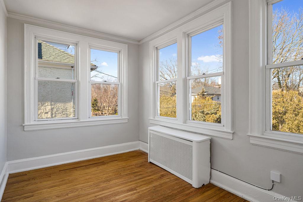135 Webster Avenue, Unit 2 Harrison, NY 10528 - Photo 16 of 25 a view of an empty room with wooden floor and a window