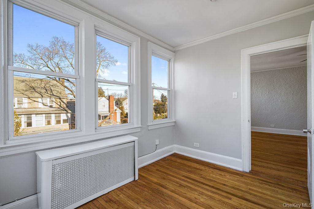 135 Webster Avenue, Unit 2 Harrison, NY 10528 - Photo 17 of 25 a view of an empty room with wooden floor and a window