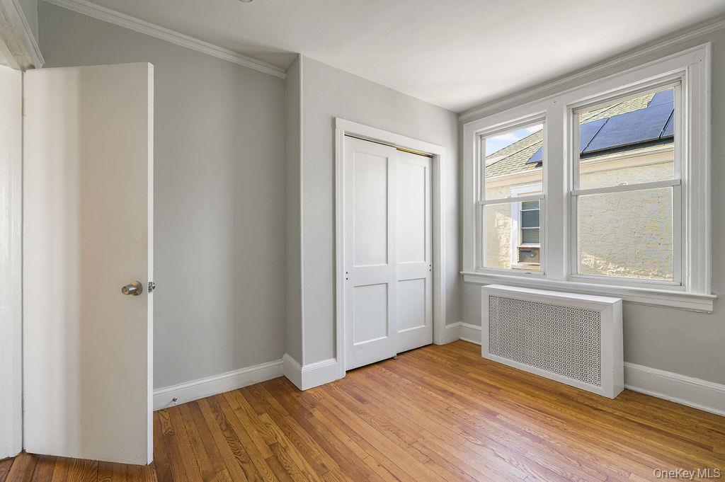 135 Webster Avenue, Unit 2 Harrison, NY 10528 - Photo 19 of 25 a view of an empty room with wooden floor and a window
