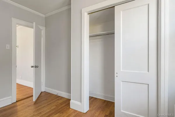 a view of empty room with wooden floor