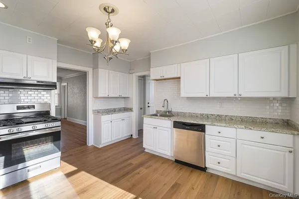 a kitchen with white cabinets and stainless steel appliances