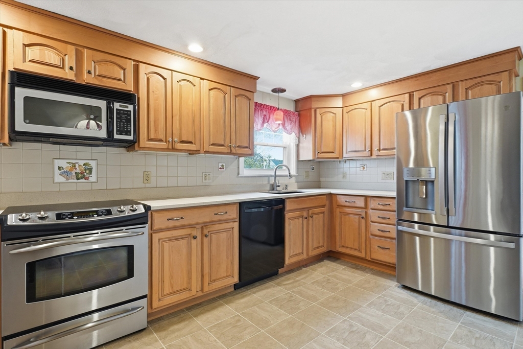 53 Kendall Street Lawrence, MA 01841 - Photo 4 of 36 a kitchen with granite countertop a refrigerator stove and microwave