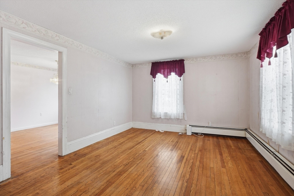 53 Kendall Street Lawrence, MA 01841 - Photo 10 of 36 an empty room with wooden floor and windows