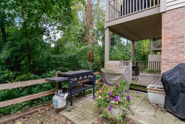 a view of a patio with table and chairs potted plants with wooden floor and fence