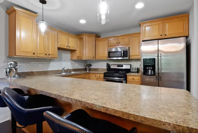 a kitchen with stainless steel appliances granite countertop a sink refrigerator and microwave