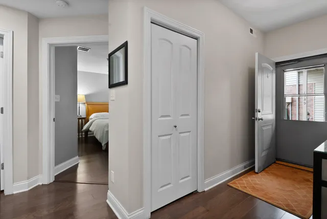 a view of a bedroom with a bed and wooden floor