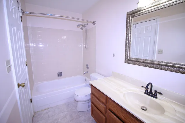 a bathroom with a sink a toilet a mirror and shower