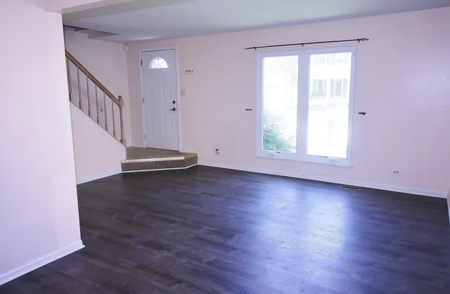 a view of a room with wooden floors and window