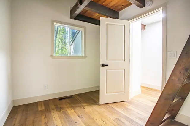 a view of an empty room with wooden floor